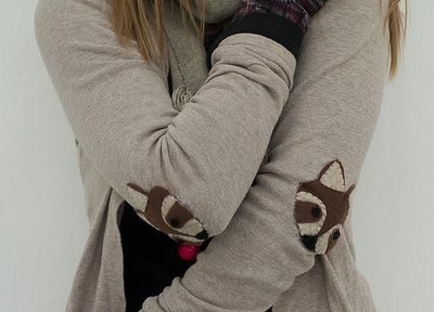 A woman in a thick woven sweater with fox patches on the elbows of her garment.