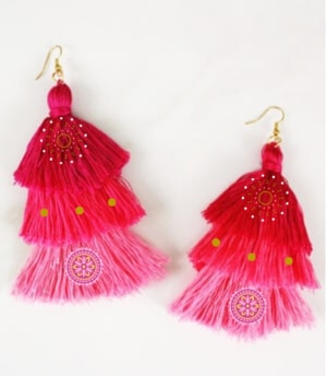 Pinkish tassel earrings made of embroidery string with golden decorative beads and charms on them